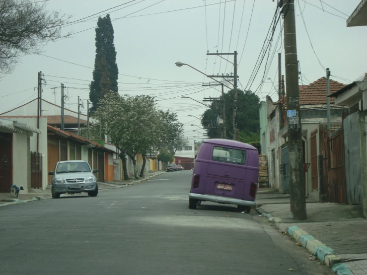 the street in front of some houses has many telephone poles