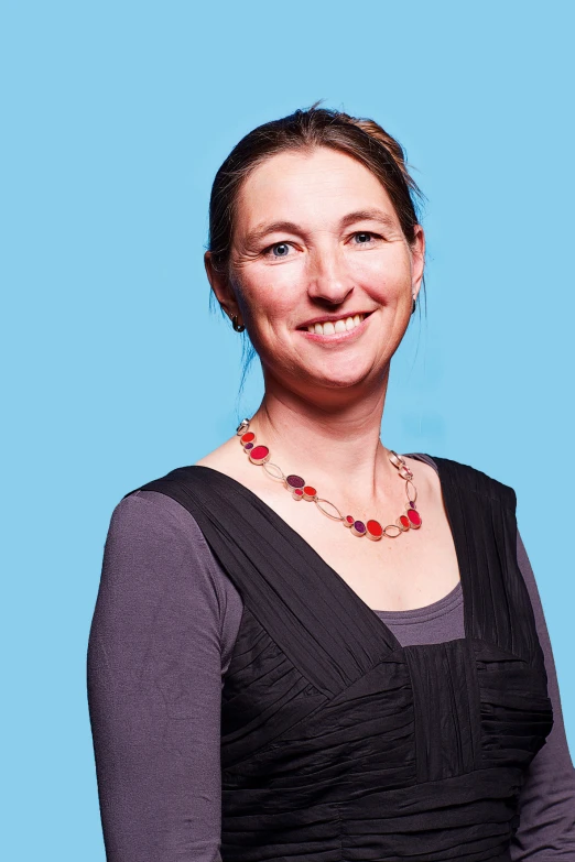 a woman wearing a necklace on a blue background