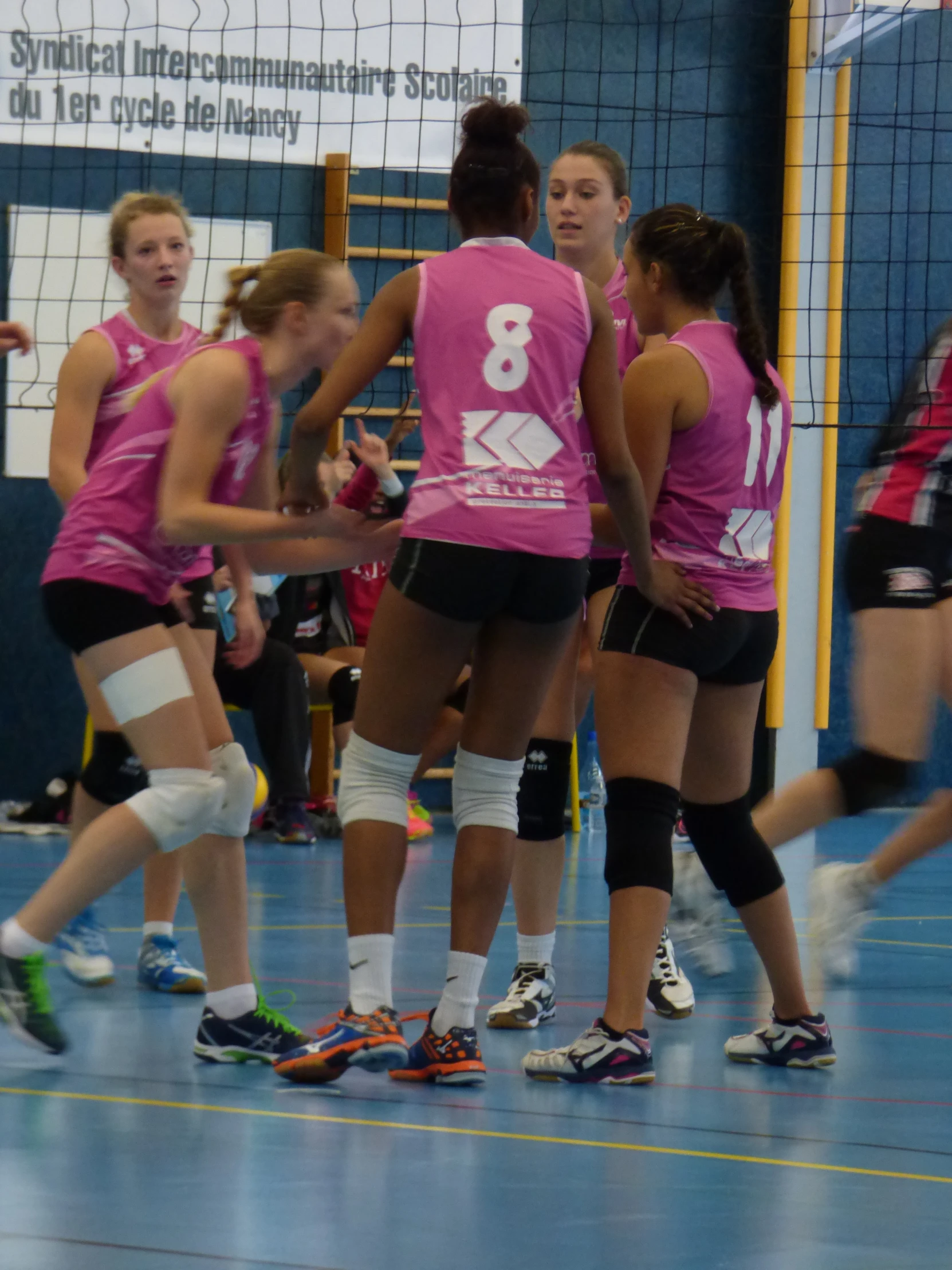 volleyball players huddle and talk on the court