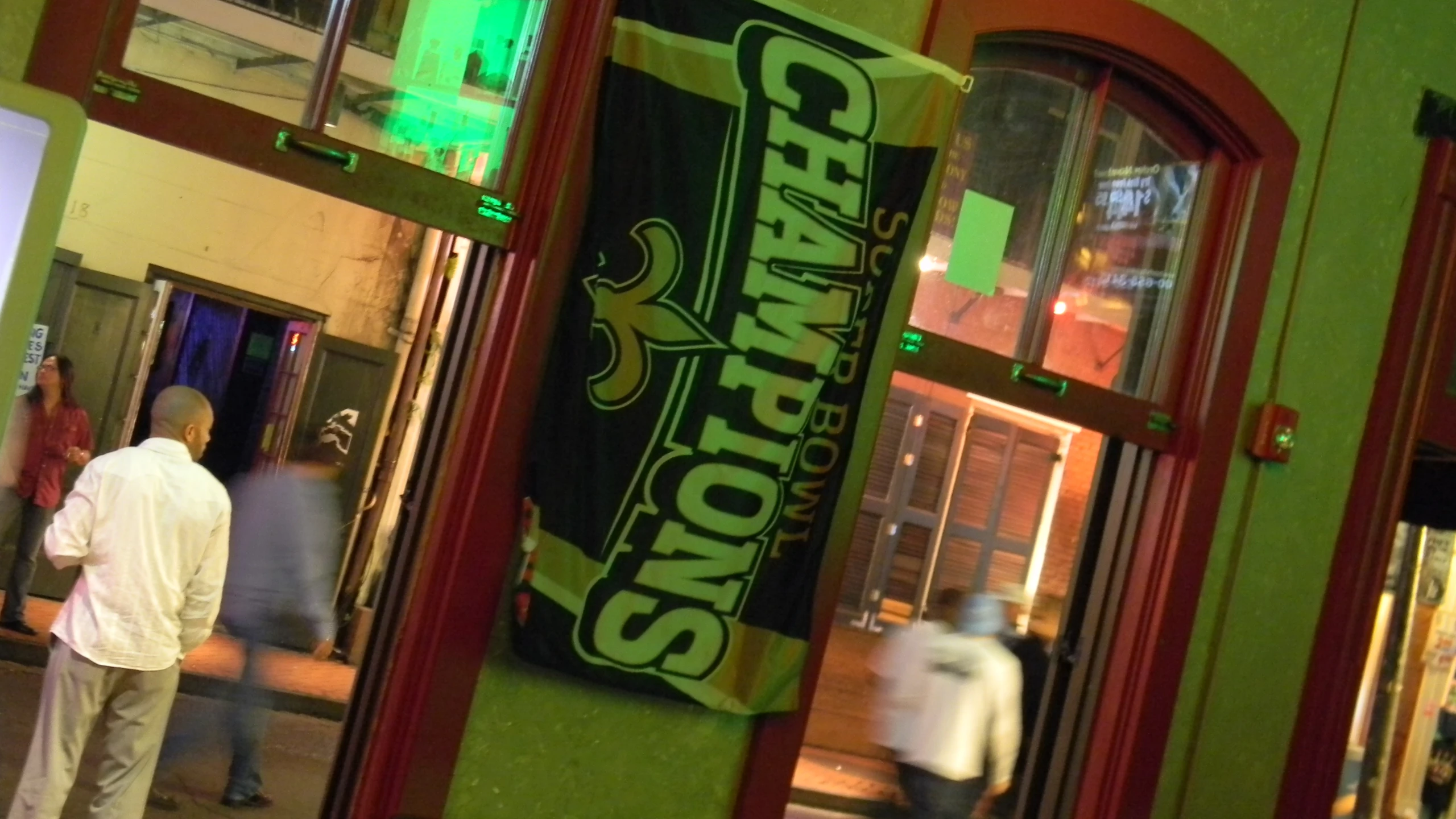 a man standing outside the entrance to a bar