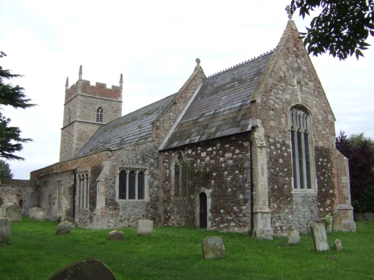 an old brick building with windows and stone headstones