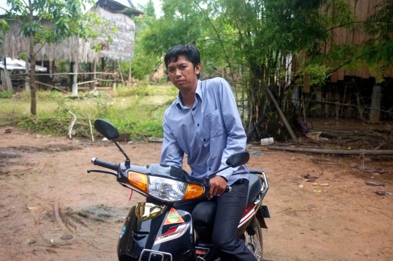 man posing on his motorbike in a small area