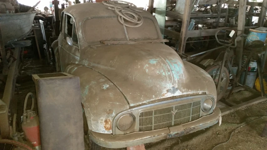 an old dirty car sitting in a garage