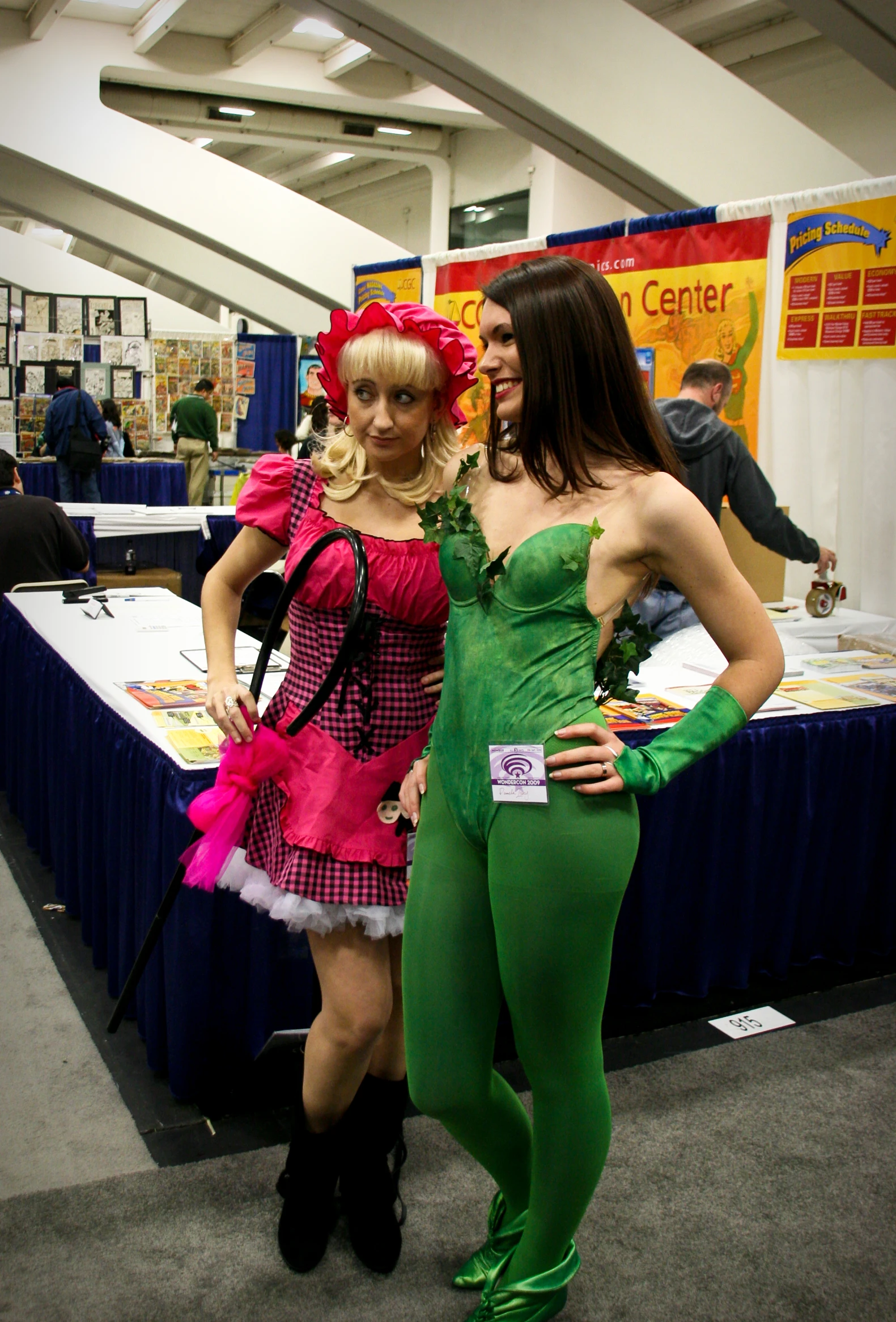 two girls are standing beside each other at a convention