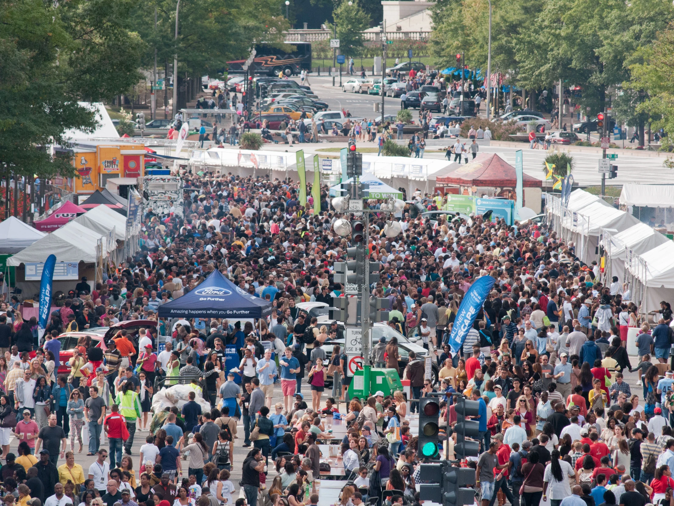 a crowd of people walking through a parking lot