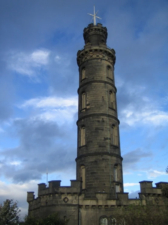 the tower is tall and has some white clouds