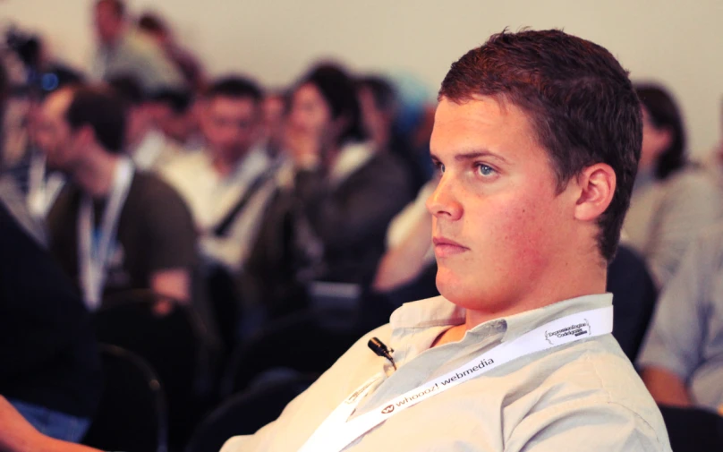 the man is waiting for the presentation in the auditorium