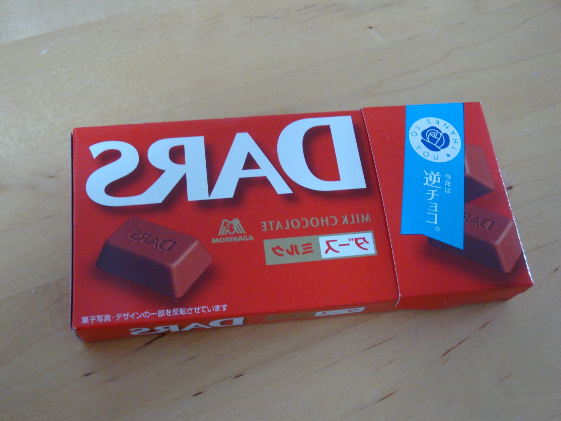 a pack of dare milk chocolate bars on top of a wooden table