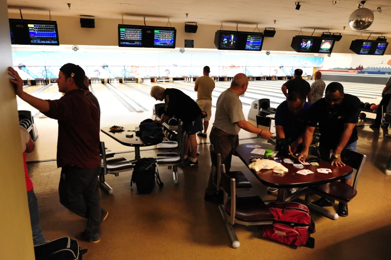 people standing and sitting at the bowling alley waiting to meet