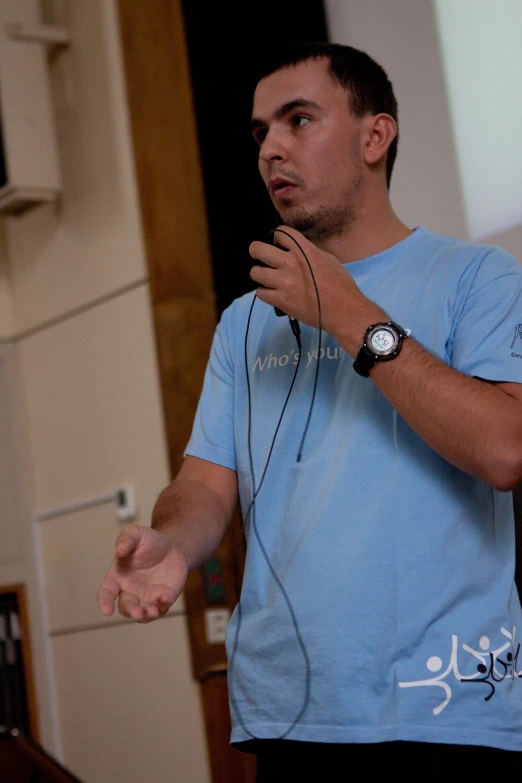 a man in a blue t - shirt playing a game with a nintendo wii controller