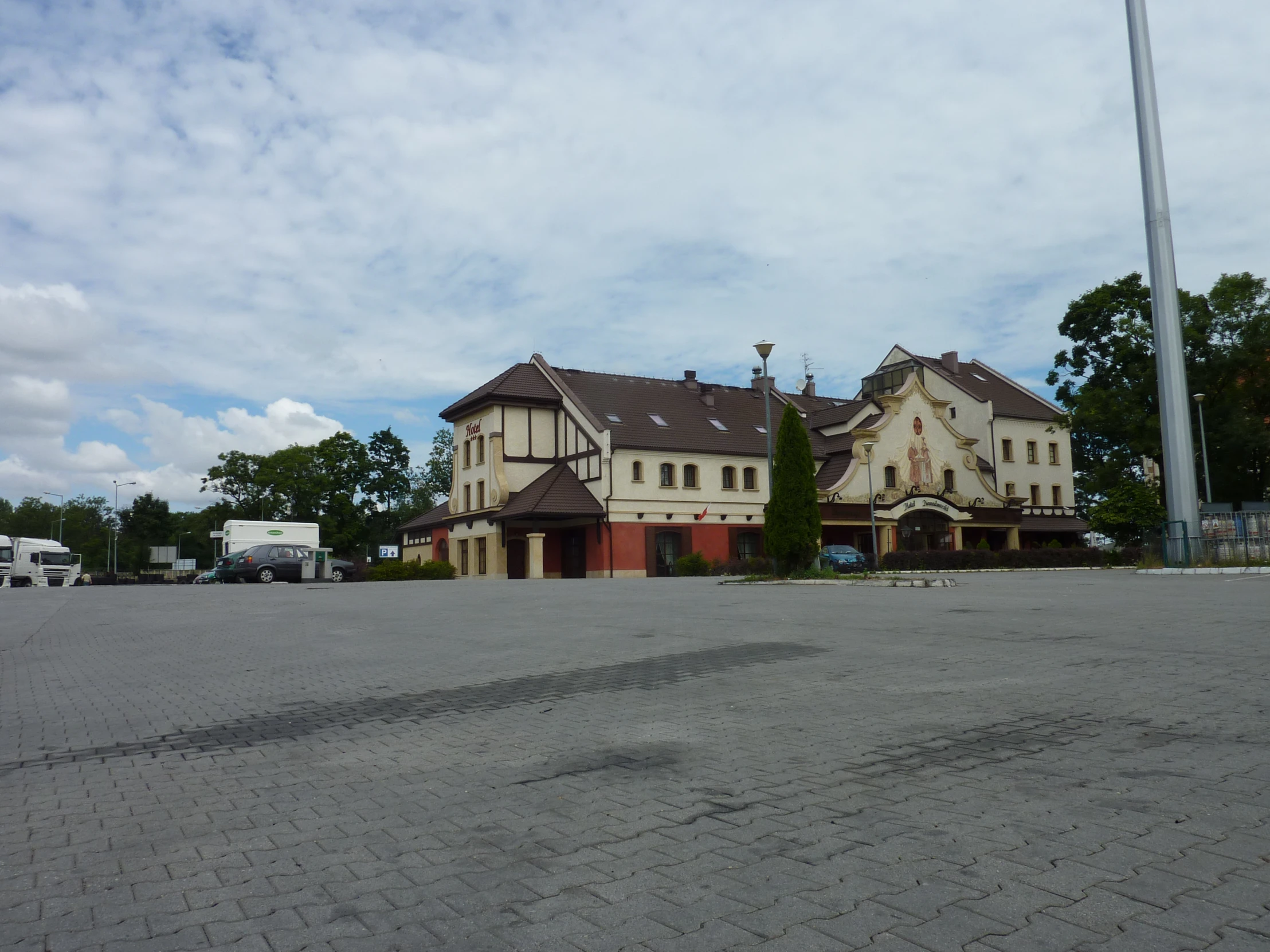 an empty parking lot with an old house in the background