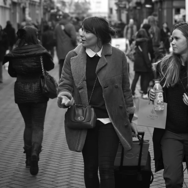 a few people walking down the street with suitcases