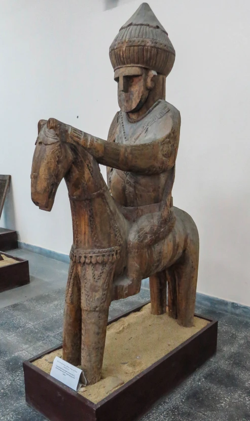 an ornate statue is holding a horse in a room