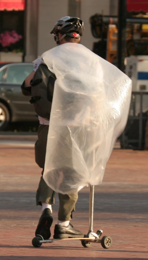 a person riding a skateboard with a large plastic bag on the back