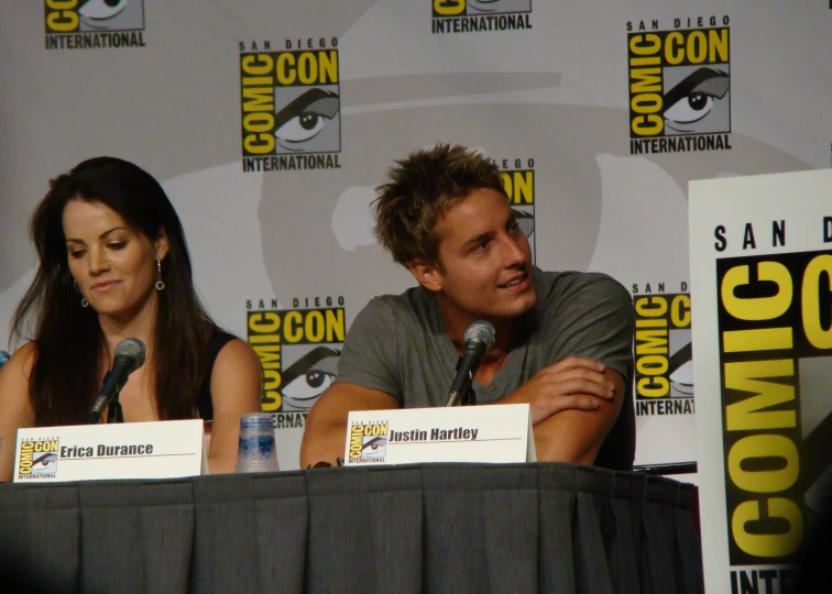 two actors are sitting in front of microphones and panel