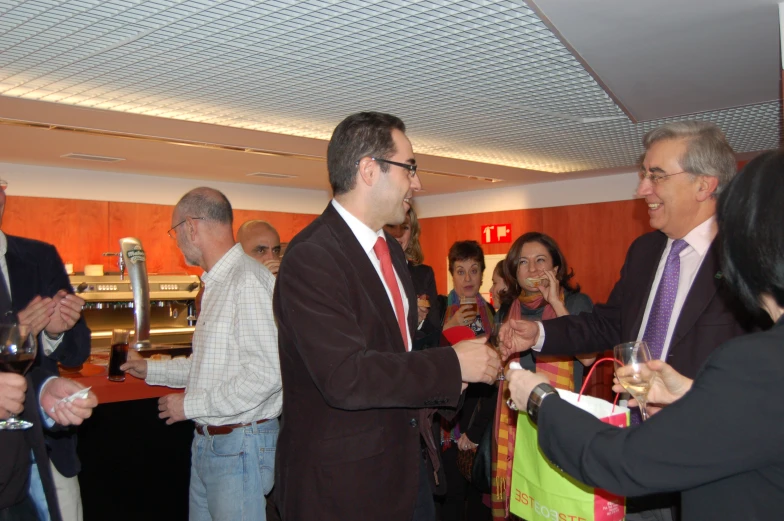 men in suits and ties having a conversation while others mingle