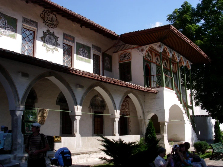 a building with arches around it and some people