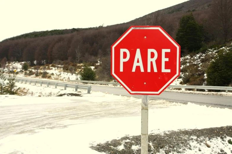 a red stop sign sitting on the side of a road