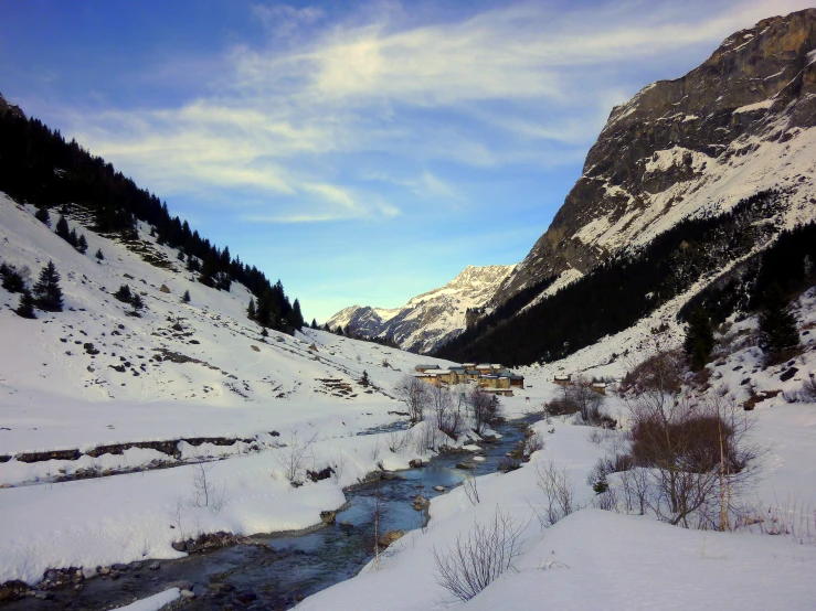 a snowy landscape with mountains in the distance