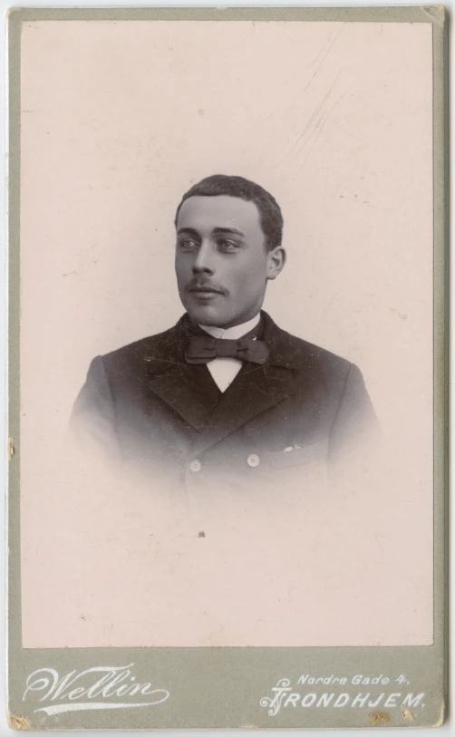 an antique portrait of a man wearing a suit and bow tie