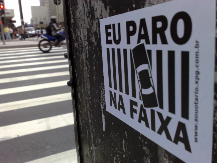 a sign reads, eu paro na faxa next to a motorcycle on the side of a street