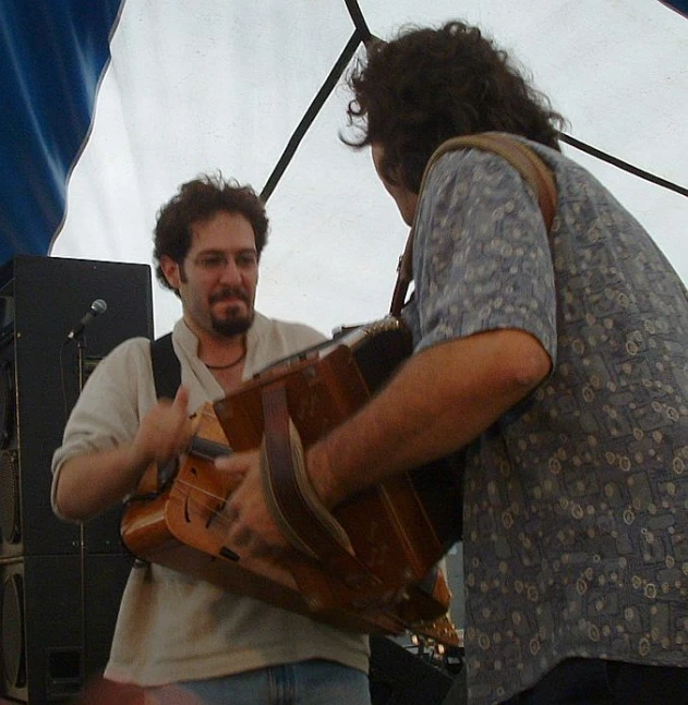 two people are looking into one another's eyes as they play the guitar