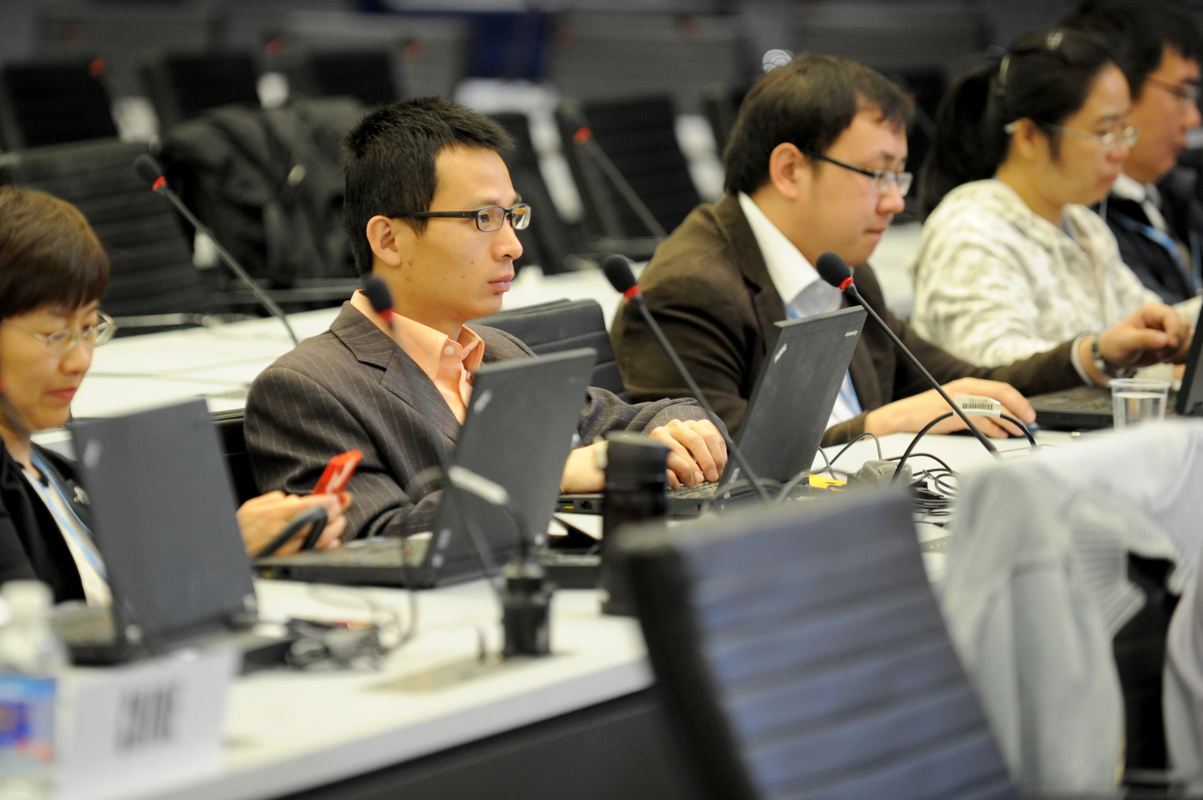 people in a conference room with their laptops