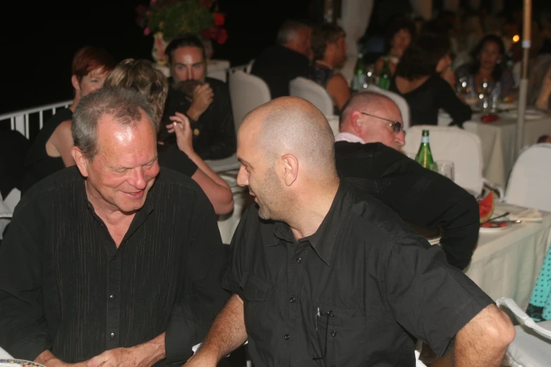 two men sitting side by side in a restaurant