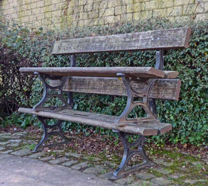 an old weathered wooden bench against a wall