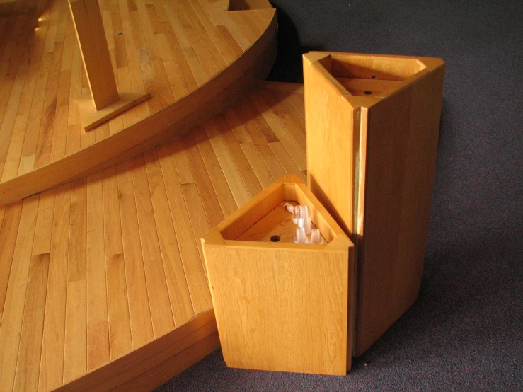 there is a wooden desk and two wooden trash cans