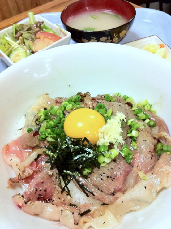 a plate with food that includes meat, vegetables and an egg