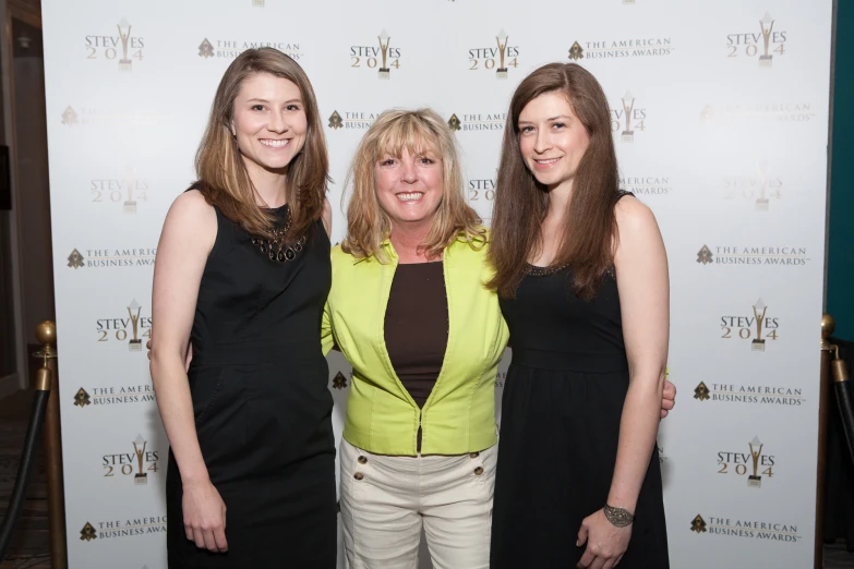 three women standing next to each other at an event