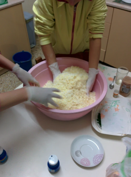 two girls in gloves are mixing together a table