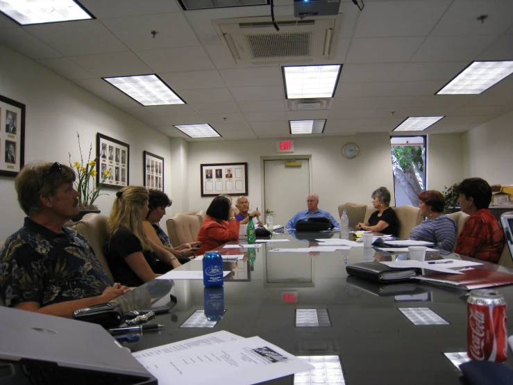 a meeting with a large table covered in papers