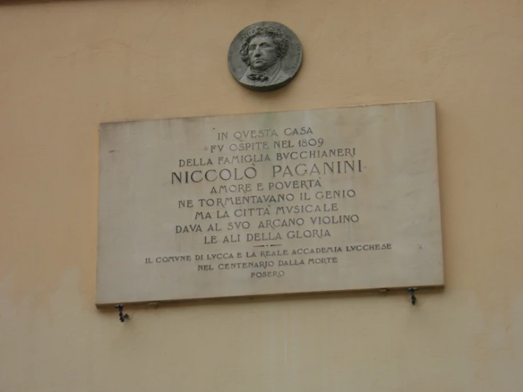 a plaque on the wall of a building that is also in italian