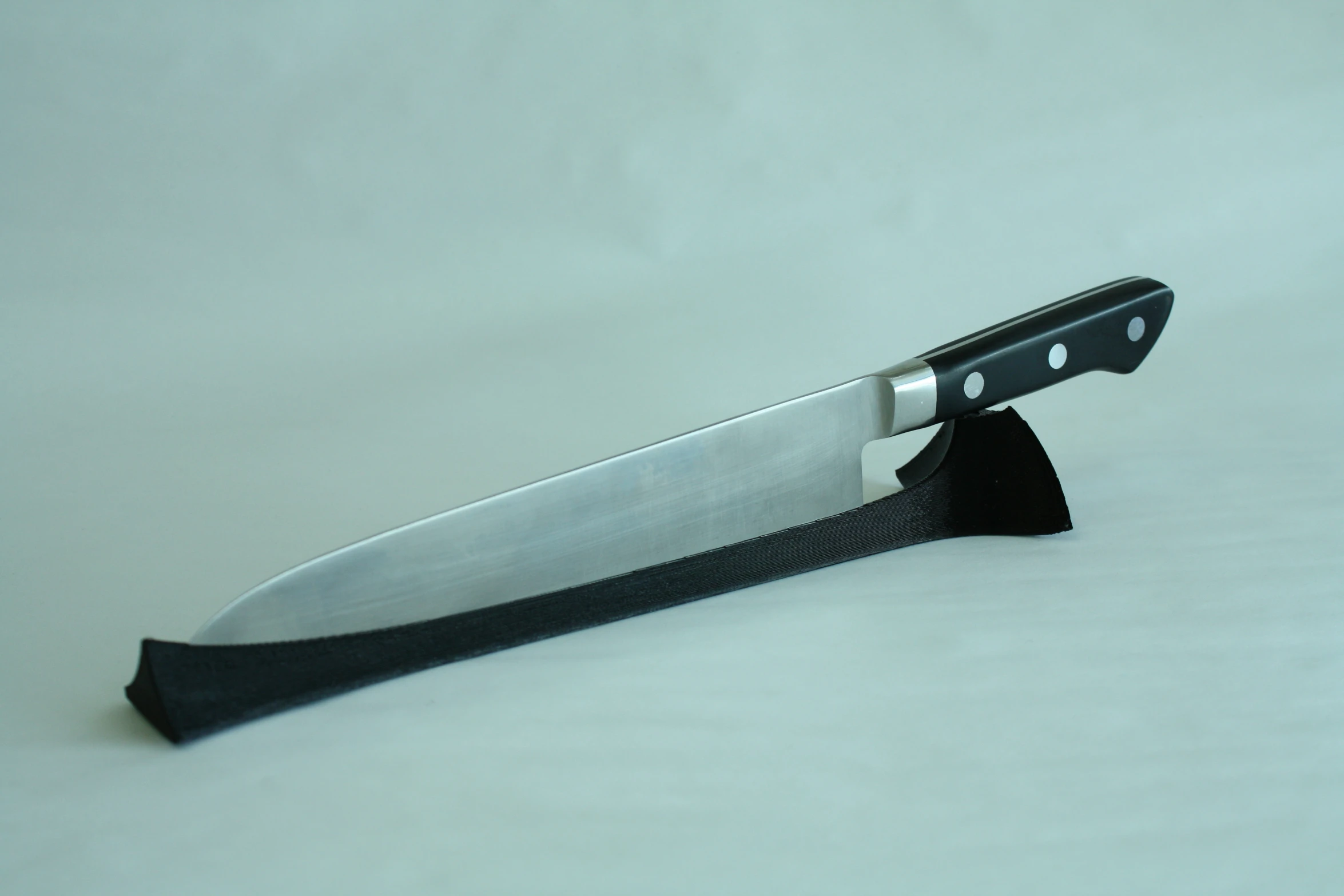 a close up of a large knife on a white table