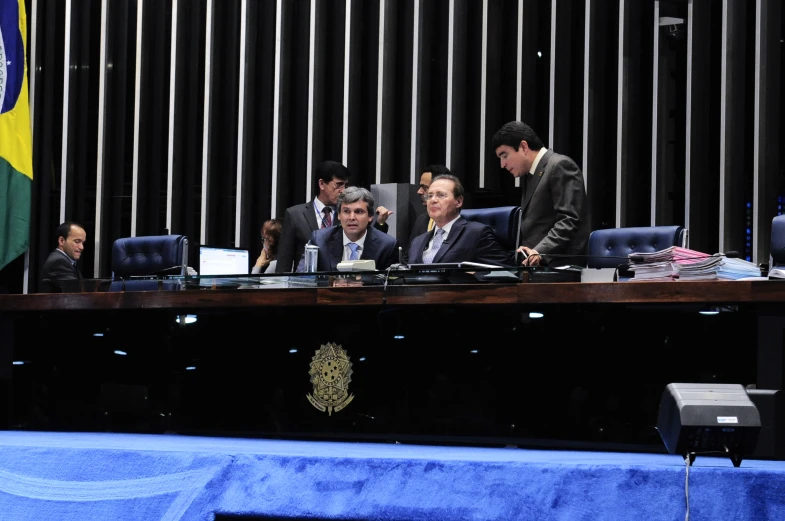 some men sitting around a long black table