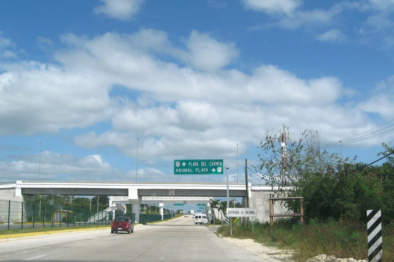 cars driving down an empty highway on a partly cloudy day