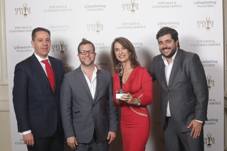 four people smiling and posing for a picture at an event