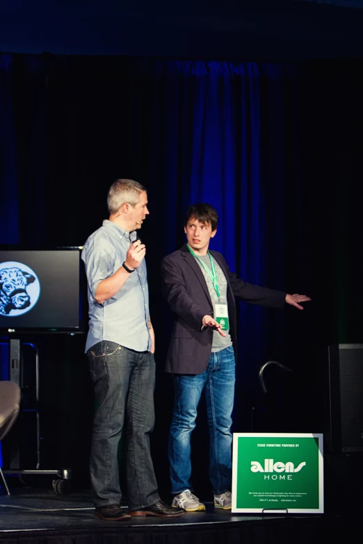 two men on stage with microphones talking to each other