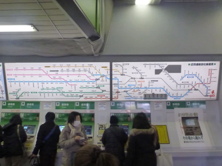 a group of people standing near a map of subway lines