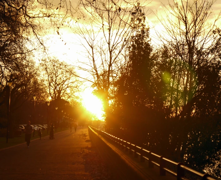 a woman walking down a path under the sun