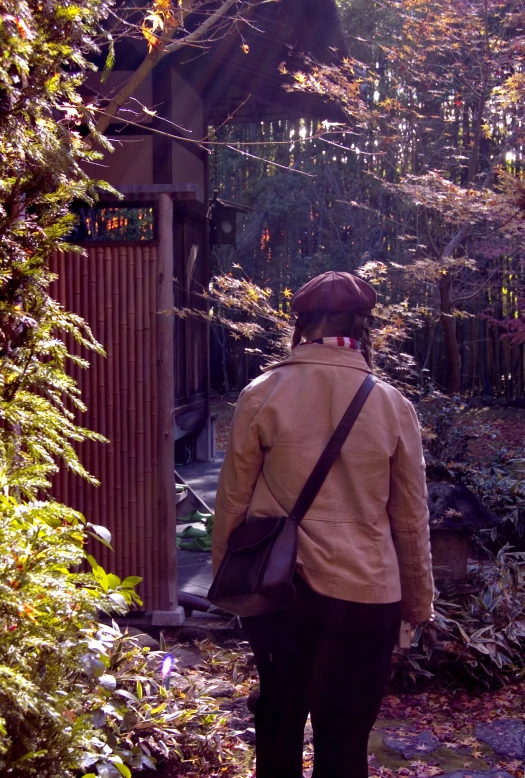 a woman walks toward a wooden shed in the woods