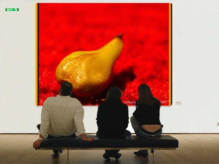 the three people sit looking at the large digital art work