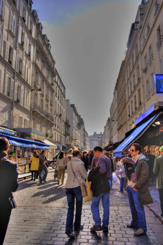 people standing in an alley surrounded by tall buildings