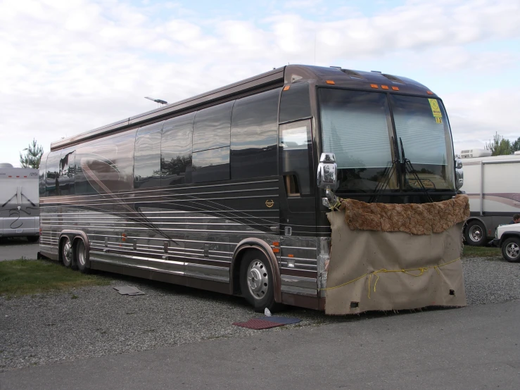 a bus covered with sand sitting on a parking lot