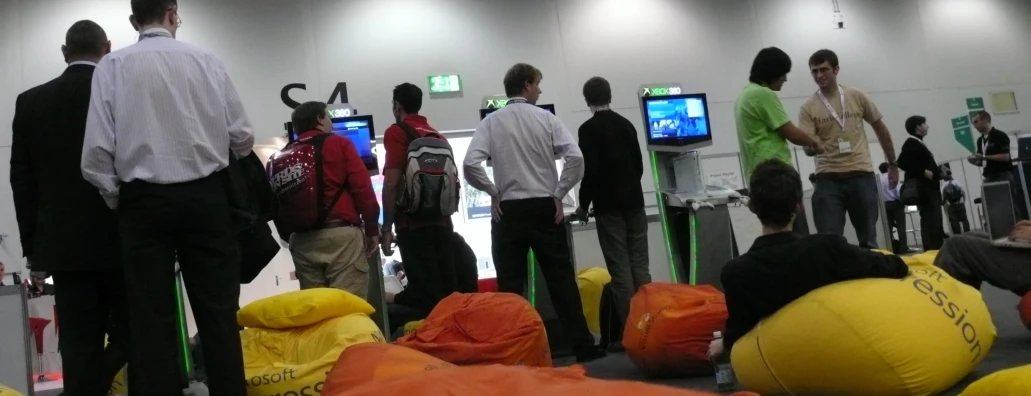 people looking at televisions in a crowded room