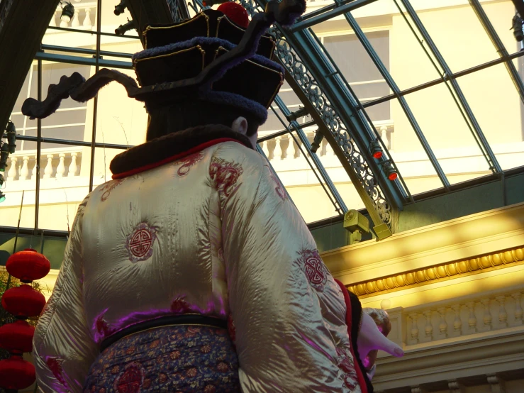 an asian lady standing under a glass roof