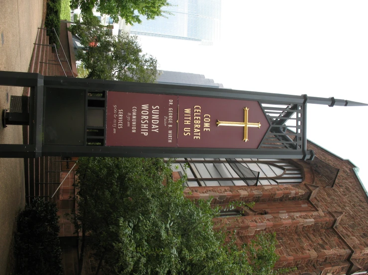 a sign on a pole next to a brick church