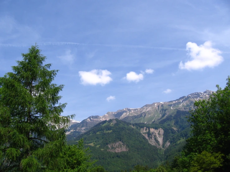 clouds and trees are in the distance as the mountain top rises